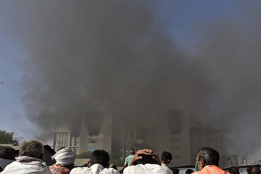 Indianos observam incêndio no Instituto Serum, em Pune, em 21 de janeiro de 2021 — Foto: AFP