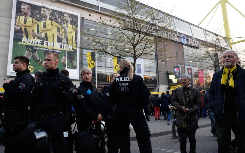 Policiais patrulham a área externa do estádio após uma explosão atingir o ônibus que transportava o time do Borussia Dortmund para a partida contra o Monaco no local, na Alemanha, na terça-feira (11) (Foto:  Odd Andersen/AFP)