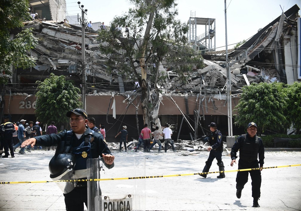 Policiais fazem cordão de isolamento em volta de prédio que desabou durante forte tremor que atingiu a Cidade do México nesta terça-feira  (Foto: Ronaldo Schemidit / AFP )