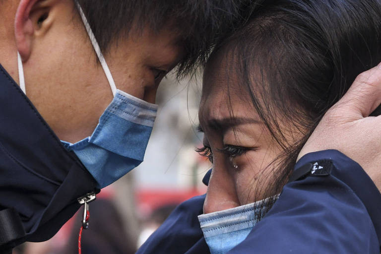 Membro de uma equipe médica que parte para Wuhan, província de Hubei, se despede de sua família na Universidade Médica de Xinjiang, em Urumqi , na região autônoma do grupo étnico Xinjiang Uygur, no noroeste da China. Ele faz parte de uma equipe de 142 médicos de Xinjiang partiu para Wuhan na terça-feira para ajudar nos esforços de controle do novo coronavírus