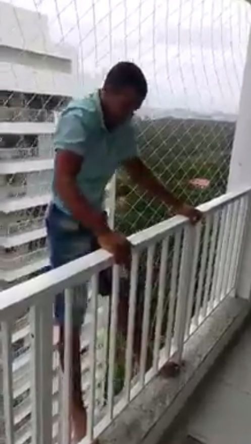 Homem se pendura do lado de fora da varanda