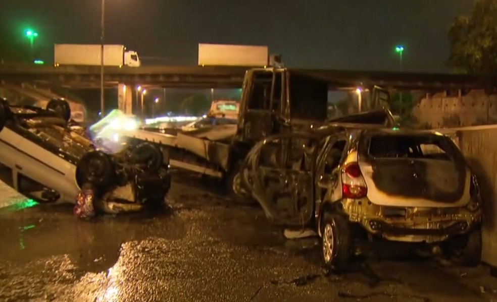 Caminhão-reboque cruzou a pista e atingiu os carros na Avenida Brasil, que pegaram fogo na hora (Foto: Reprodução/ TV Globo)