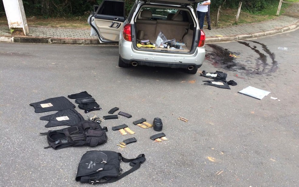 Local do tiroteio em Guararema, com coletes de criminosos apreendidos e poÃ§a de sangue ao lado de carro onde estavam assaltantes que foram mortos em troca de tiros â?? Foto: Giba Bergamin/ TV Globo