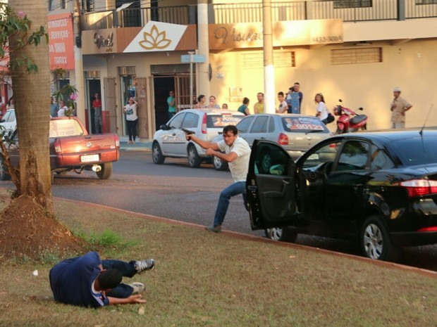 Homem identificado como funcionário da prefeitura de Itumbiara Gilberto Ferreira do Amaral, de 53 anos, atirou contra cabo da PM Vanilson João Pereira (caído no chão), vice governador José Eliton e candidato José Gomes durante carreata em Itumbiara Goiás (Foto: Reprodução/TV Anhanguera)