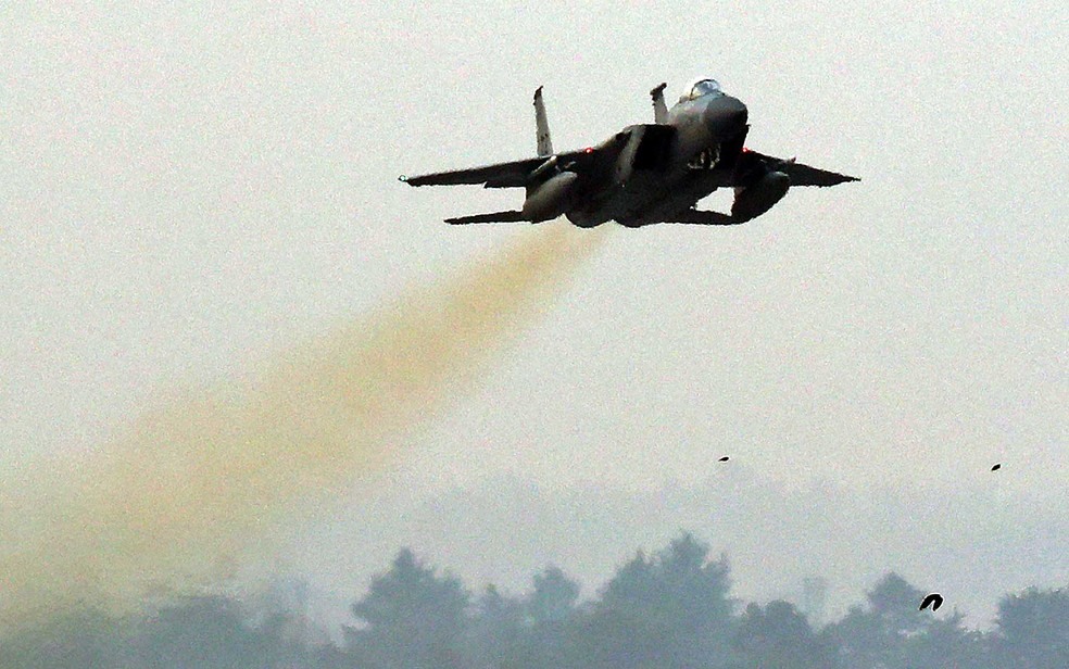 Um caça F-15 da Força Aérea dos Estados Unidos voa sobre uma base aérea sul-coreana em Gwangju (Foto: YONHAP / via AFP Photo)