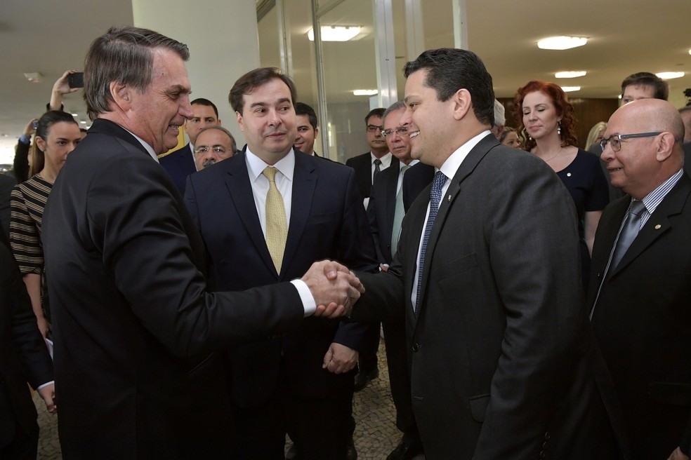 Presidente Jair Bolsonaro cumprimenta o presidente do Senado, Davi Alcolumbe; ao centro, o presidente da CÃ¢mara, Rodrigo MiA â?? Foto: Marcos BrandÃ£o/Senado Federal