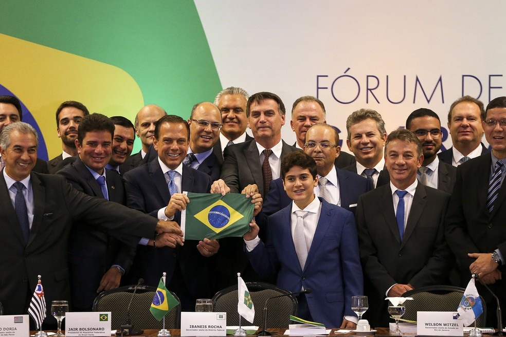 O presidente eleito Jair Bolsonaro posa com uma bandeira do Brasil entre governadores eleitos e reeleitos para o mandato que se inicia em 2019, durante o FÃ³rum de Governadores em BrasÃ­lia â?? Foto: Marcelo Camargo/AgÃªncia Brasil