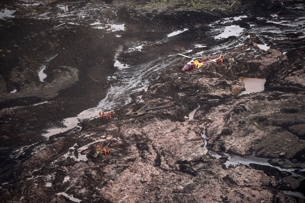 Vista aÃ©rea mostra bombeiros trabalhando em lama apÃ³s rompimento de barragem em Brumadinho â?? Foto: Douglas Magno/ AFP