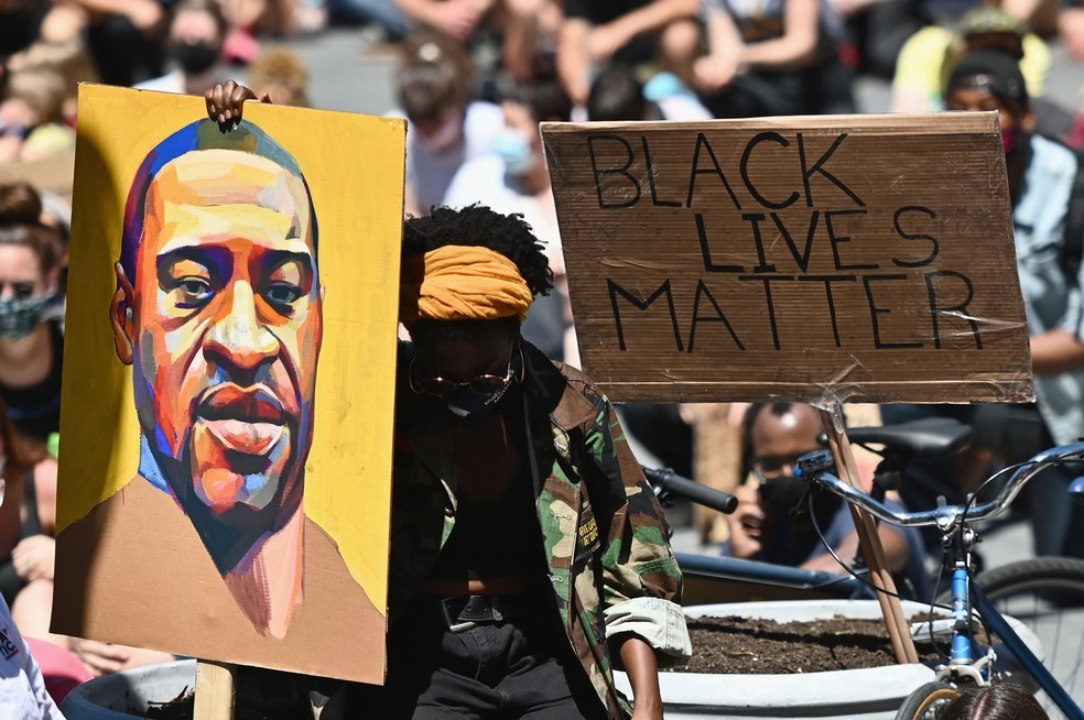 Manifestante segura cartaz com retrato de George Floyd durante protesto em Nova York, na segunda-feira (8)  — Foto: Angela Weiss / AFP