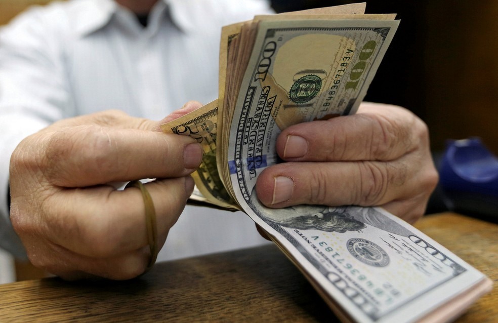 Homem conta notas de dÃ³lar em casa de cÃ¢mbio no Cairo, Egito. â?? Foto: Reuters