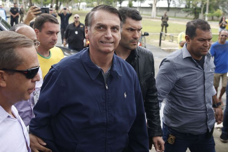 O candidato Ã  PresidÃªncia Jair Bolsonaro (PSL) chega Ã  seÃ§Ã£o eleitoral na Escola Municipal Rosa da Fonseca, na Vila Militar, acompanhado do filho FlÃ¡vio Bolsonaro, que Ã© candidato ao Senado. Agentes da PolÃ­cia Federal e militares do ExÃ©rcito