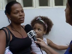 Moradora de Vila Laura chegou cedo a posto de saúde para vacinar filha (Foto: Imagens / TV Bahia)