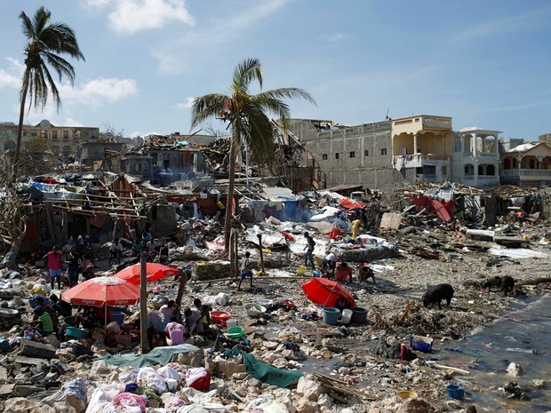 Pessoas se reúnem à beira-mar em local atingido pelo furacão Matthew em Jeremie, no Haiti (Foto: Carlos Garcia Rawlins/Reuters)