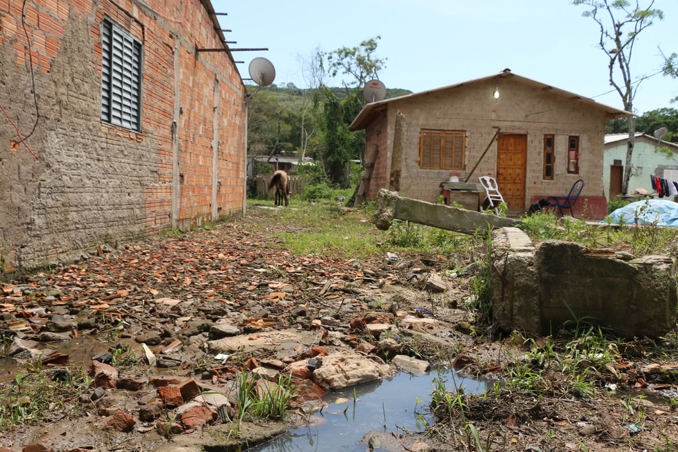 Em ocupação na Zona Sul de Porto Alegre esgoto corre a céu aberto e casas de madeira se alternam com de alvenaria (Foto: Hygino Vasconcellos/G1)