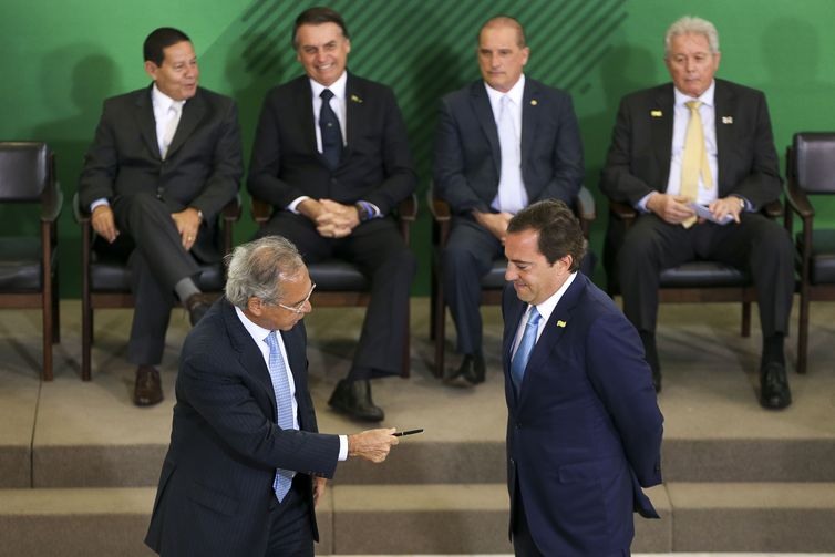 O ministro da Economia Paulo Guedes, assina o termo de posse do presidente da Caixa, Pedro GuimarÃ£es, durante cerimÃ´nia de posse aos presidentes dos bancos pÃºblicos.  