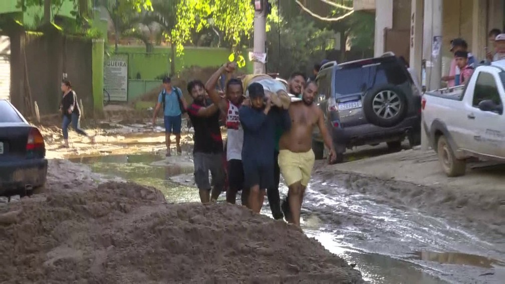 Moradores retiraram homem dos escombros apoiado em uma porta, que foi usada como maca â?? Foto: ReproduÃ§Ã£o/ TV Globo