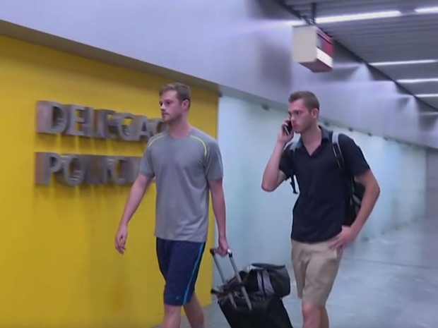 Nadadores Gunnar Bentz e Jack Conger chegaram a embarcar e foram retirados de dentro do avião (Foto: Reprodução/Globo)