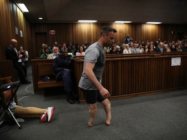 O medalhista paralímpico Oscar Pistorius caminha sem suas próteses de pernas na corte durante nova audiência na Alta Corte em Pretória, África do Sul. Ele aguarda para ouvir a nova sentença no caso de homicídio de sua namorada, Reeva Steenkamp, em 2013 (Foto: Siphiwa Sibeko/AFP)