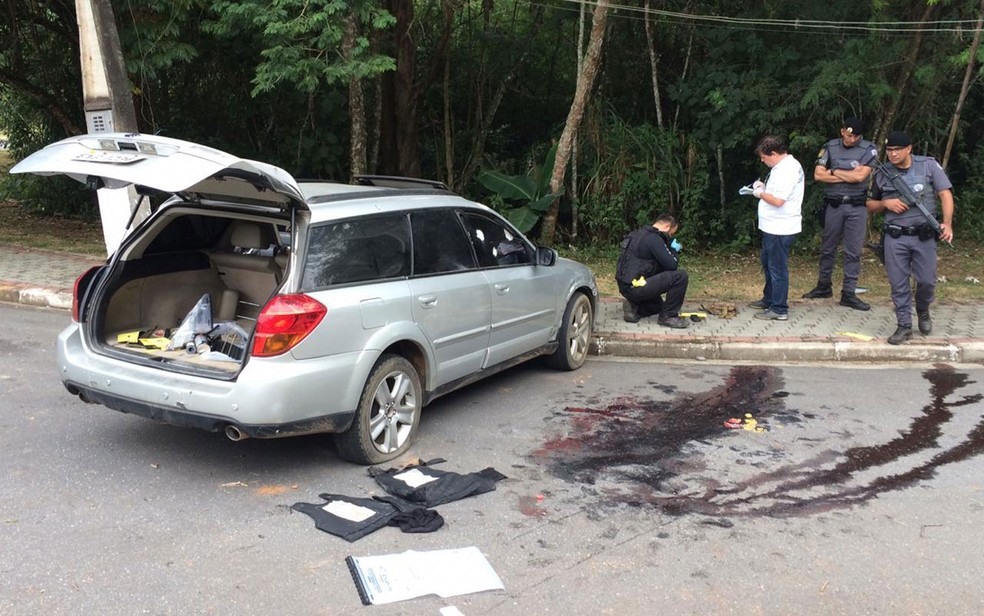 Policiai e poÃ§a de sangue em local onde criminosos foram mortos apÃ³s tentativa de assalto a bancos de Guararema, em SÃ£o Paulo â?? Foto: Giba Bergamin/TV Globo