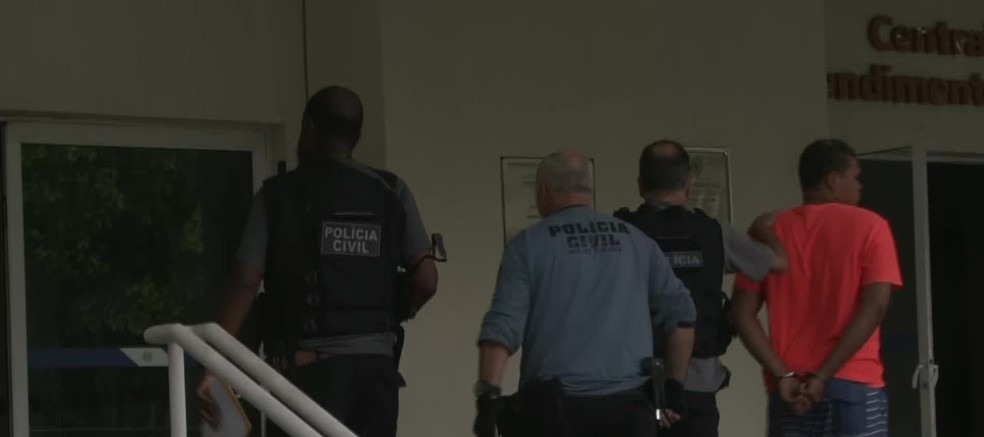 Polícia conduz preso na Cidade da Polícia, na Zona Norte do Rio (Foto: Reprodução/ TV Globo)