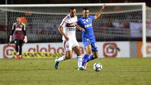 O sÃ£o-paulino NenÃª disputa a bola com o cruzeirense Henrique