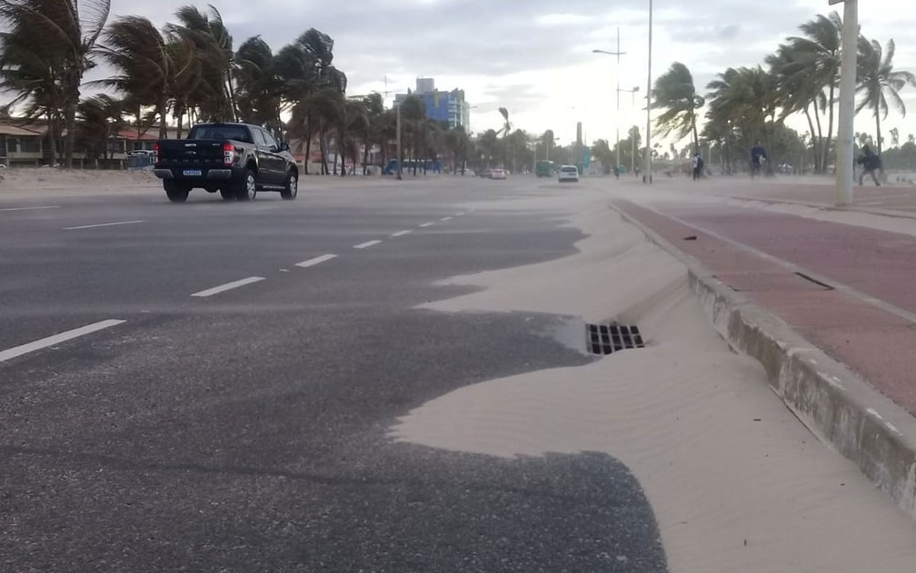 Ventos fortes arrastam areia da praia para calÃ§adÃ£o e pista de veÃ­culos em PiatÃ£  â?? Foto: Cid Vaz/TV Bahia