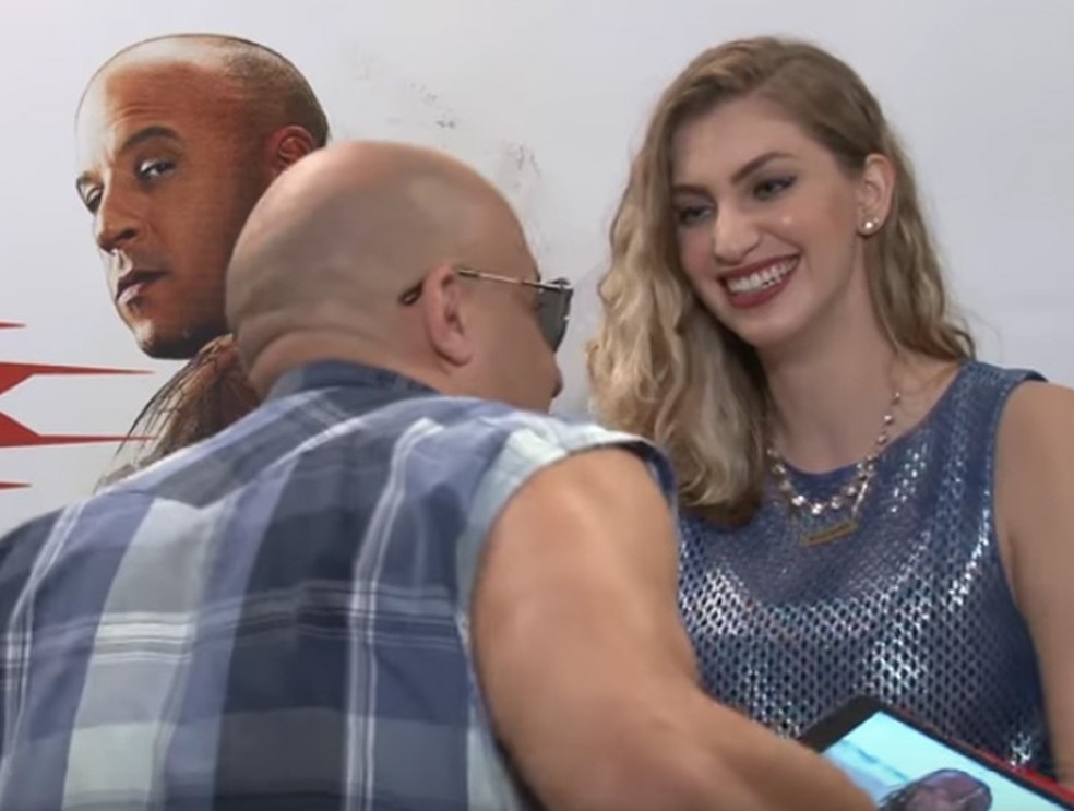 Vin Diesel se ajoelha diante de Carol Moreira durante entrevista em São Paulo (Foto: Reprodução/YouTube/Carol Moreira)