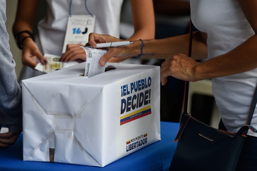 Mulher vota em plebiscito convocado pela oposição contra o presidente da Venezuela, Nicolás Maduro, neste domingo (16)  (Foto: Juan Barreto / AFP )