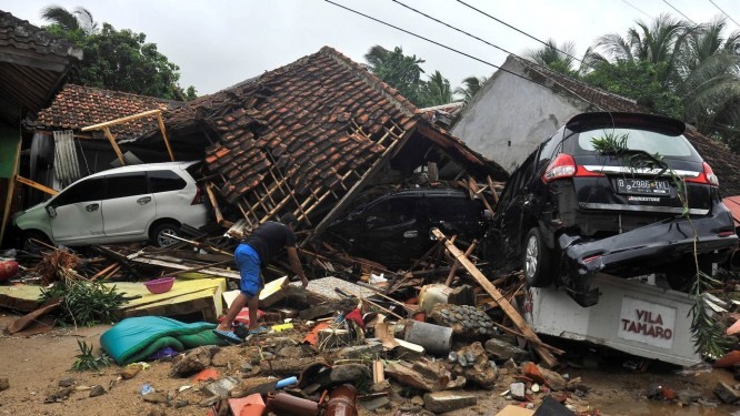 Moradora tenta retirar pertences dos escombros de sua casa, apÃ³s tsunami Foto: Antara Foto / Reuters