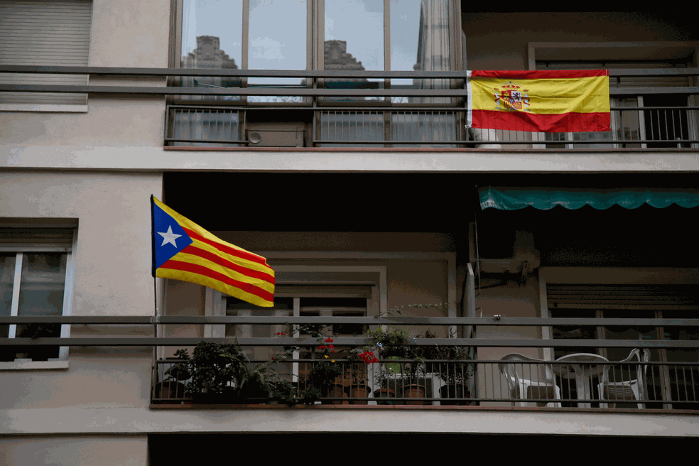 Vizinhos exibem em suas sacadas bandeiras da Catalunha (à esquerda) e da Espanha em prédio em Barcelona  (Foto: Bob Edme/AP)